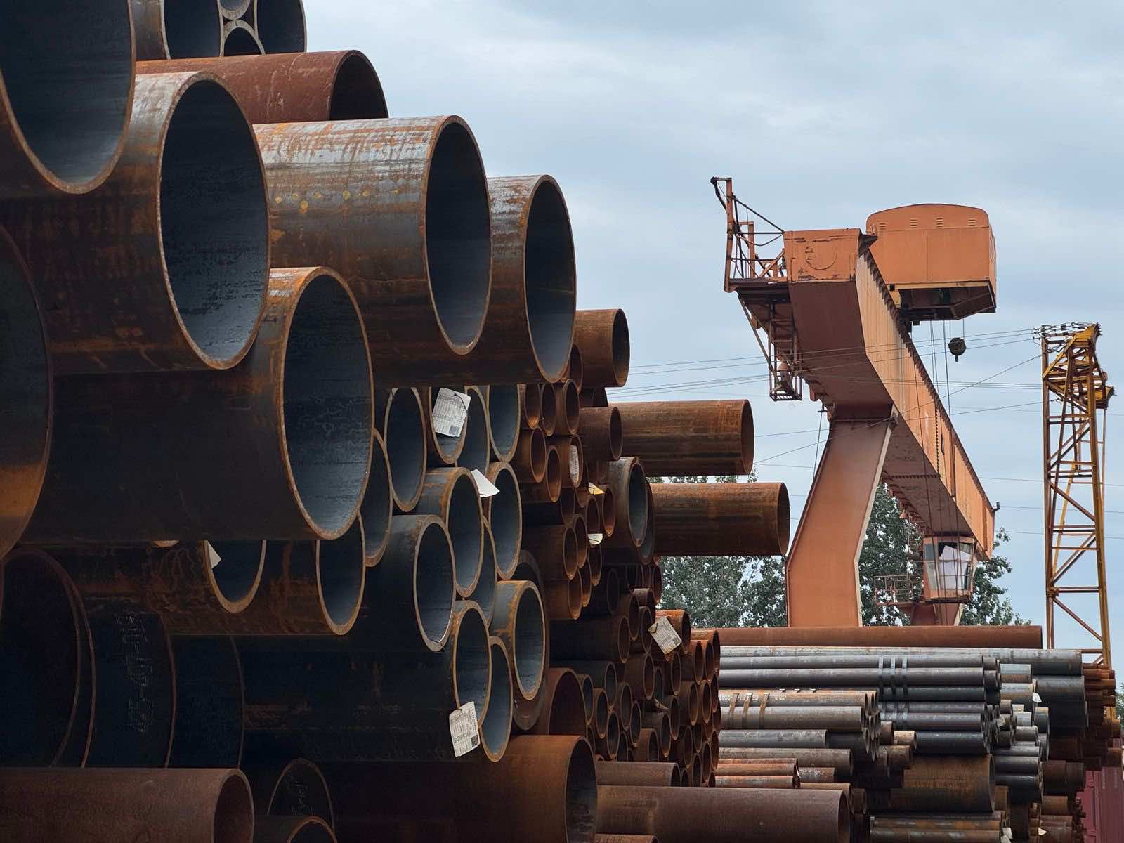 Stacked steel pipe sections in an industrial supply yard